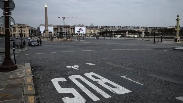 Place de la Concorde déserte, obélisque au fond et marquage « SOS » peint au sol.