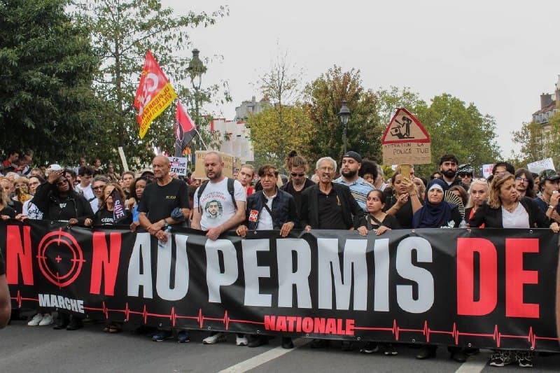 Tête du cortège derrière la banderole « Non au permis de tuer », drapeaux et pancartes levés.