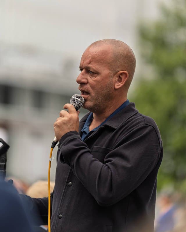 Un orateur prend la parole au micro pendant le rassemblement.