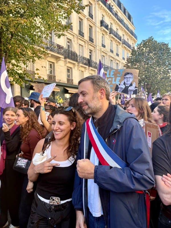 Thomas Portes, ceint de son écharpe tricolore, pose avec une jeune manifestante au milieu du cortège.
