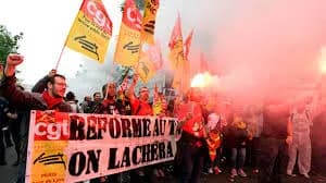 Manifestation avec drapeaux de la CGT et fumigène, derrière une banderole « Réforme du rail, on lâchera rien »
