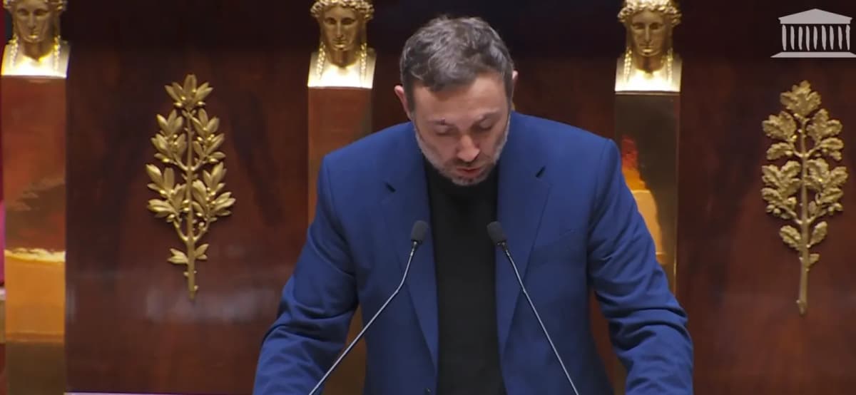 Retransmission de l’Assemblée nationale : un homme en veste bleue lit son intervention à la tribune de l’hémicycle.