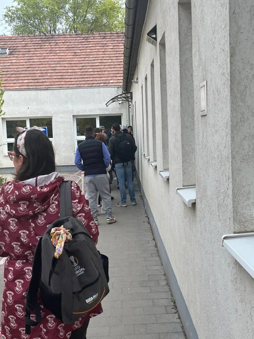 File d’attente le long d’un bâtiment devant l’entrée d’un bureau de vote.